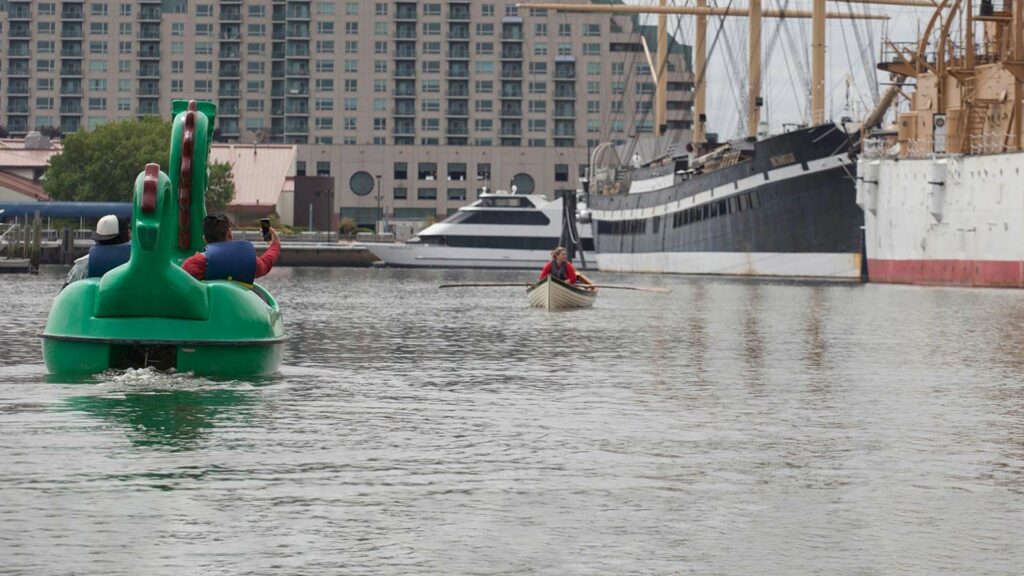 Guests paddling in a dragon boat on the water at The Independence Seaport Museum