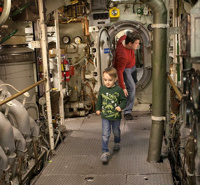 Father and son walking through Submarine Becuna at The Independence Seaport Museum