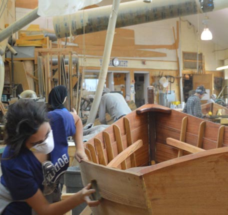 Workers restoring boats at The Independence Seaport Museum