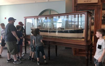 Guests looking at a glass-enclosed model of a ship at The Independence Seaport Museum