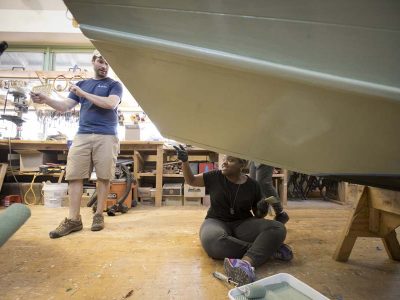 Workers restoring a boat in the ship builders shop at The Independence Seaport Museum